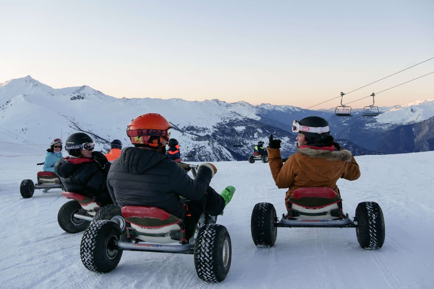 Personnes descendant une piste enneigée sur des mountains kart à Valloire